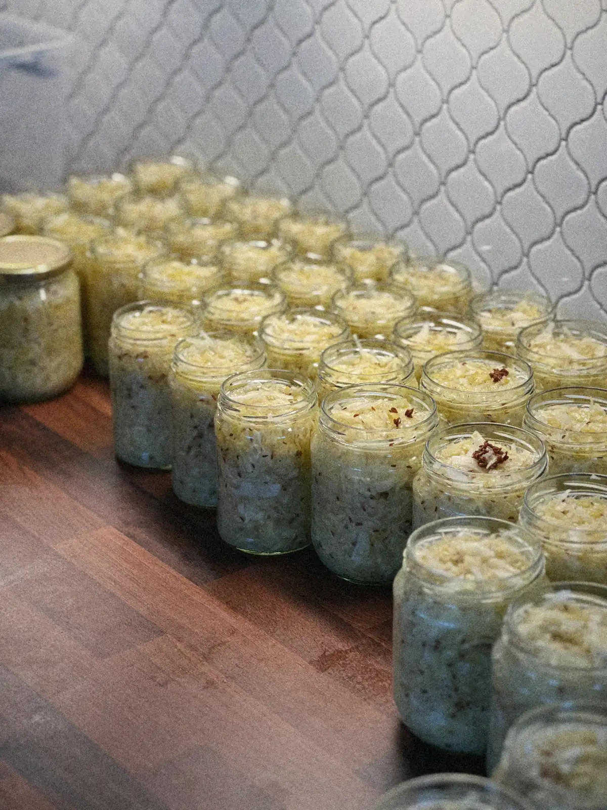 Rader med nyfylte glass surkål på kjøkkenbenken